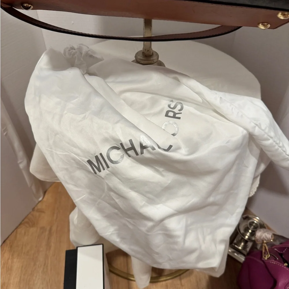 Michael Kors Emblemed satchel style purse. Strap has some gold chain and leather